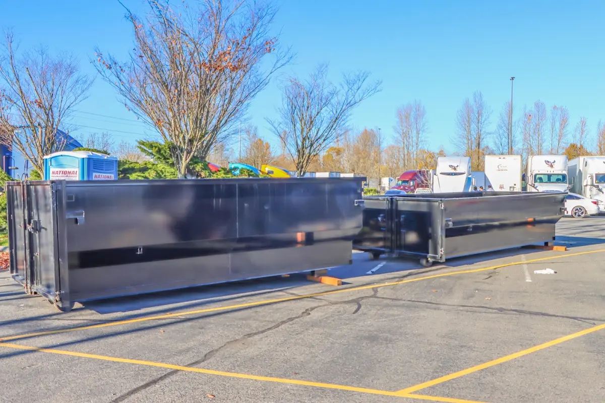 Professional dumpster rental service with roll-off container on residential driveway in Harrah